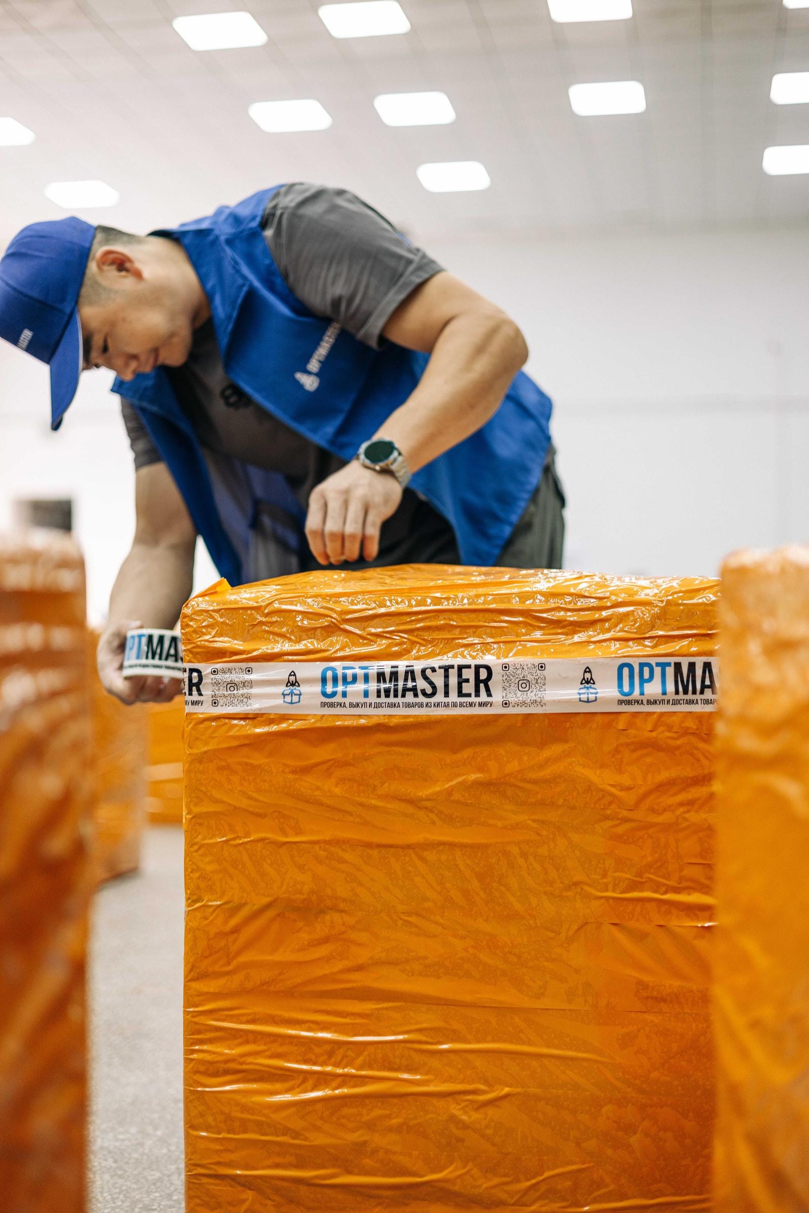 Товари з Китаю оптом — працівник OptMaster пакує оптову партію товару на складі в Гуанчжоу.