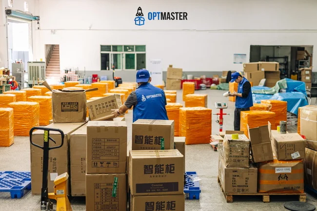 Працівники OptMaster сортують та упаковують вантаж зі складу в Китаї. Доставка товарів в Україну, імпорт, логістика.