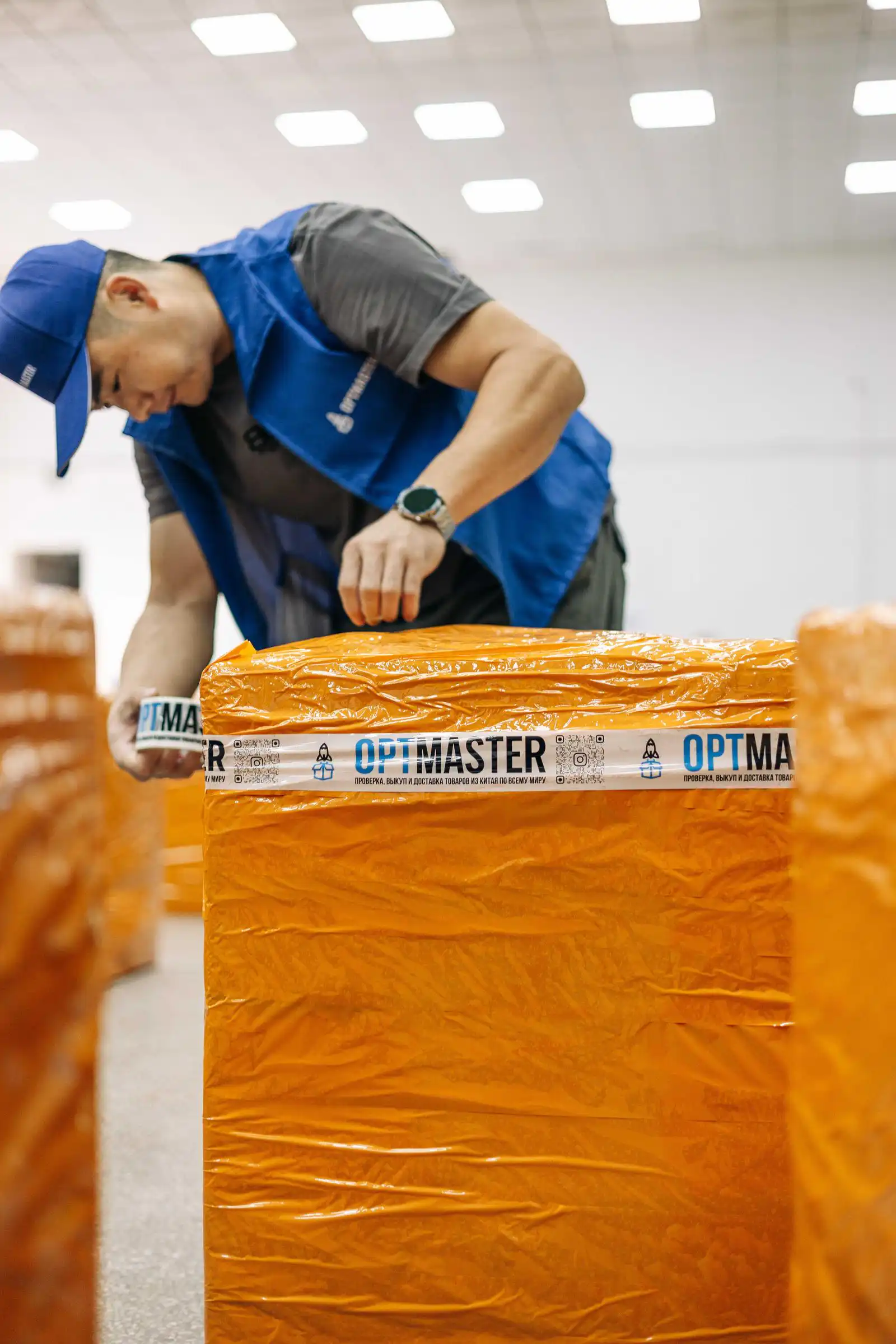 Працівник OptMaster пакує вантаж фірмовим скотчем на складі в Гуанчжоу для доставки з Китаю в Україну.