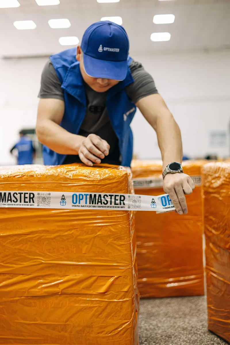 Співробітник OptMaster брендує вантаж з Китаю фірмовим скотчем на складі в Гуанчжоу.
